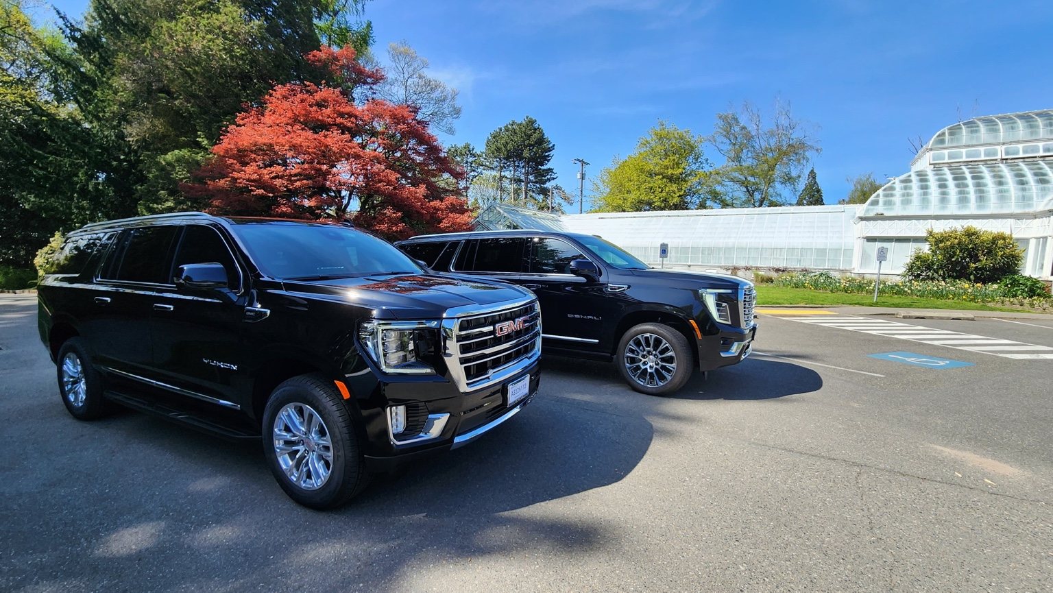 Two black GMC Yukon SUVs